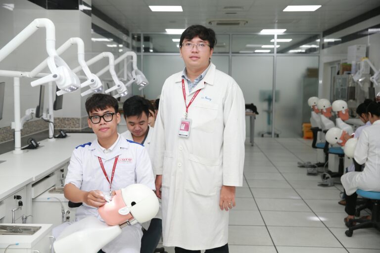 Group of dental students learning with the guidance of a professor in an AI-equipped dental training lab.