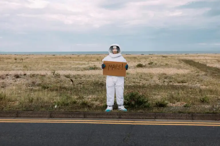Astronaut holding Mars sign representing future colonization and dental challenges.
