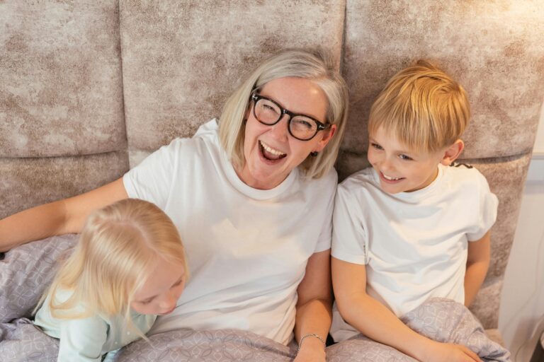Grandmother sharing a joyful moment with grandchildren, symbolizing multigenerational oral health.